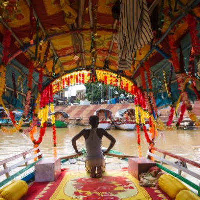 Chitrakoot, Madhya Pradesh, India : A boatman rows on a colourful boat on the Mandakini river where during their exile period Lord Rama, Lakshmana and Sita took bath.
